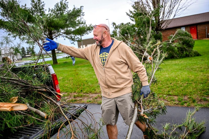 Fulton Schools custodian Clay Inman clears branches from the elementary school grounds after an overnight storm caused damage to utility poles, wires, trees and bushes on Wednesday, April 15, 2026, in Middleton. Inman said that he didn't see any tornadoes when the storm passed through overnight but he said it sounded like a freight train coming through the area.
