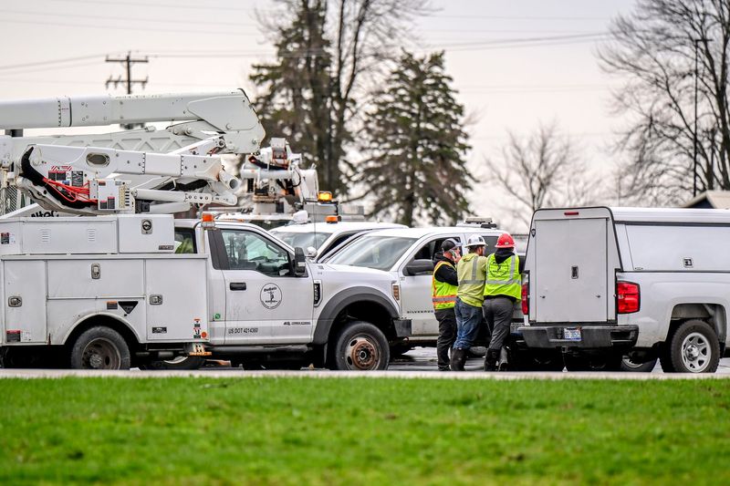Utility crews stage in the parking lot at Fulton Elementary School where overnight storms damaged utility poles and downed wires causing power outages on Wednesday, April 15, 2026, in Middleton.