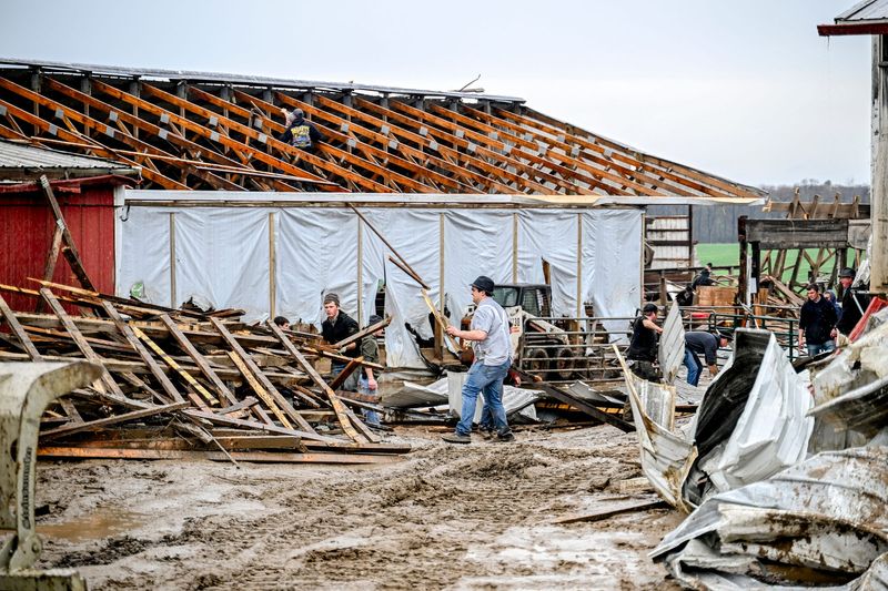 People work to clean up debris from damage to Hull's Dairy Farm after overnight storms on Wednesday, April 15, 2026, on Vickeryville Road in Fenwick.