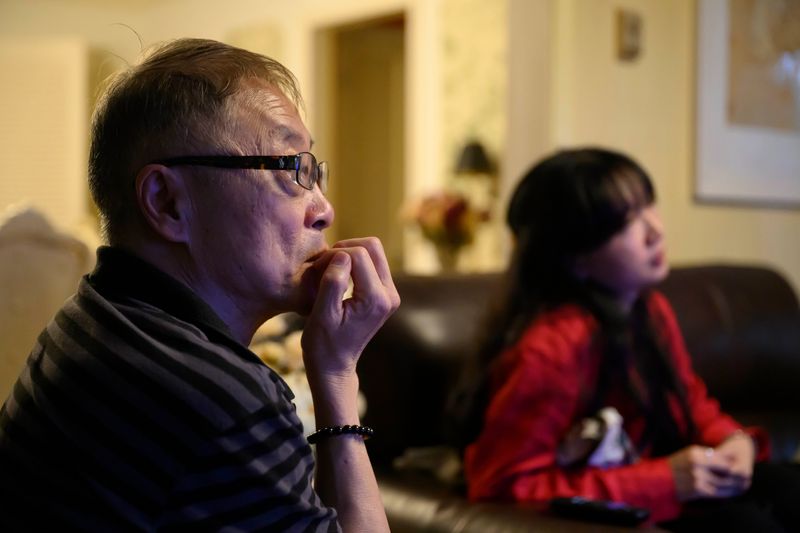 Yuchuan Ding, father of “Jeopardy!” star Jamie Ding, left, and Jessie Ding, Jamie’s sister, right, watch from their living room as Jamie continues his streak with his 24th consecutive win on Wednesday, April 15, 2026 in Grosse Pointe Shores, Mich.