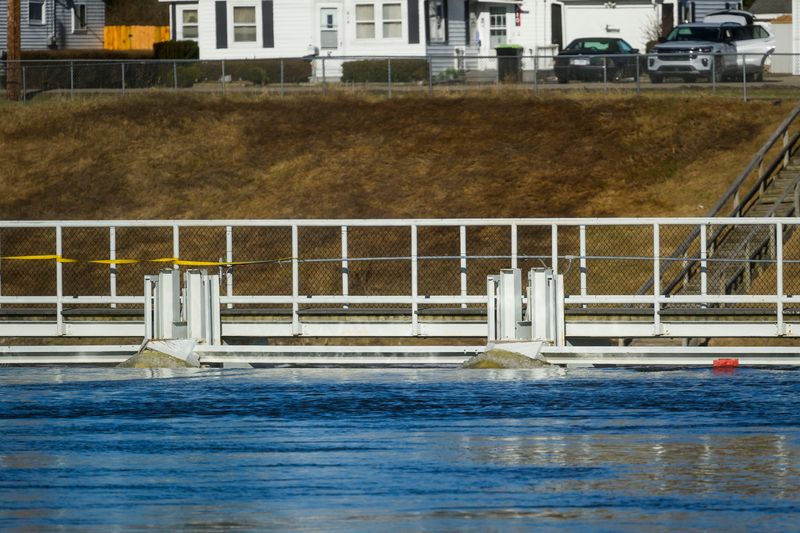 Water pushes up against the Cheboygan Dam Thursday, April 16, 2026 in Cheboygan, Mich. As of Thursday afternoon, the water level behind the dam was about five inches from cresting, potentially leading to a dam failure and major erosion to the earthen area surrounding the boat lock channel.