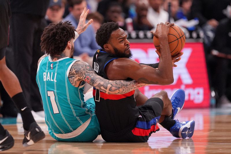 Hornets guard LaMelo Ball (1) and Pistons forward Paul Reed (7) scramble for the loose ball during the second half at Spectrum Center.