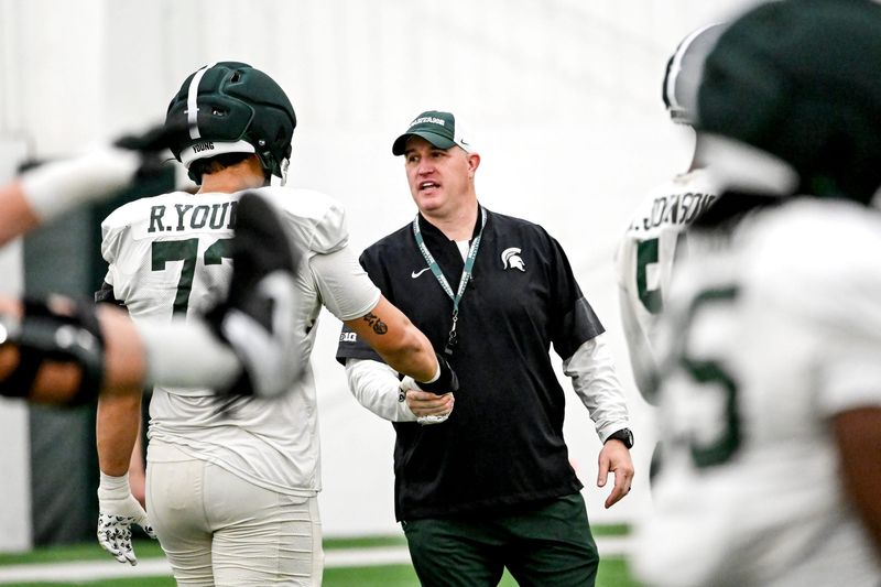 Michigan State's head coach Pat Fitzgerald, right, talks with Rustin Young during spring football practice on Tuesday, April 14, 2026, in East Lansing.