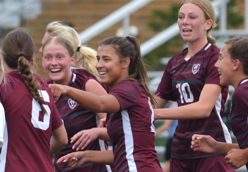 Holland Christian's Renna Gravenhof, second from left, celebrates with Addison Slagh and Julie Miedema after a goal against Zeeland East on Friday, April 17, at Holland Christian High School.