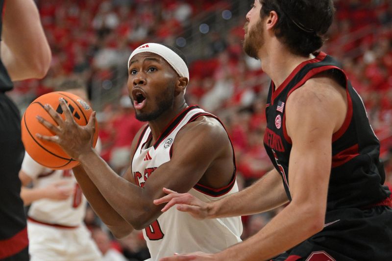 Mar 7, 2026; Raleigh, North Carolina, USA; NC State Wolfpack guard Tre Holloman (5) brings the ball to the basket against Stanford Cardinal guard Benny Gealer (5) during the first half at Lenovo Center. Mandatory Credit: Zachary Taft-Imagn Images
