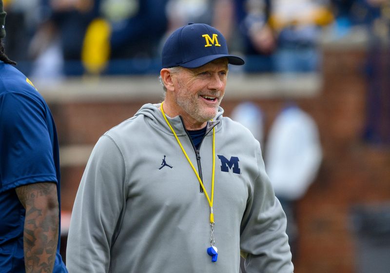 New Michigan head football coach Kyle Whittingham smiles as he walks around the field before the Maize vs. Blue Spring Game at Michigan Stadium.
