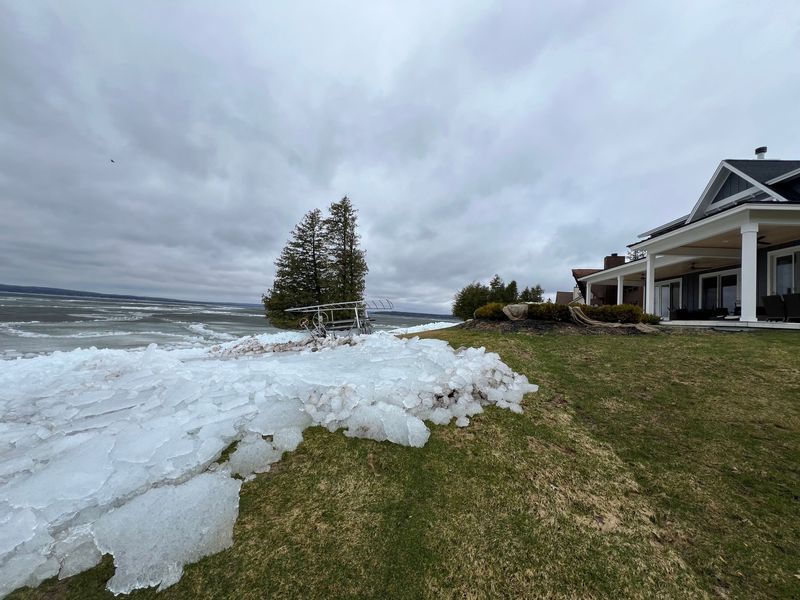 Ice accumulates on the shorelines of houses on the east side of Burt Lake in Cedar Point, Michigan on Saturday, April 18.