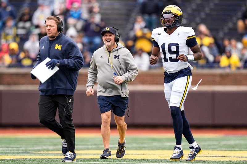 Michigan offensive coordinator Jason Beck, left, head coach Kyle Whittingham, center, and quarterback Bryce Underwood run across the field during the spring game at Michigan Stadium in Ann Arbor on Saturday, April 18, 2026.