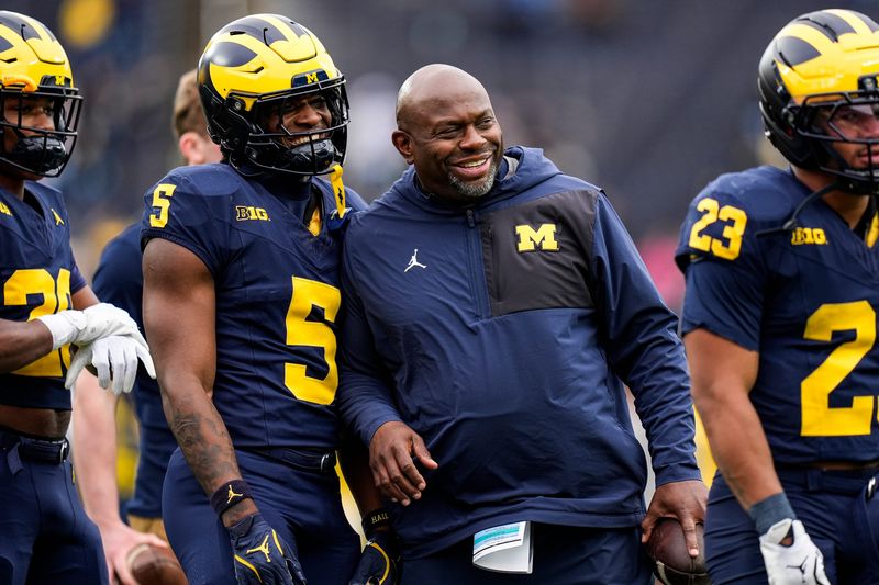 Michigan running backs coach Tony Alford, center, talks to running back Savion Hiter (5) before the spring game at Michigan Stadium in Ann Arbor on Saturday, April 18, 2026.