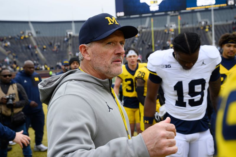 New Michigan head football coach Kyle Whittingham gathers his players, including QB Bryce Underwood (19), together at midfield at the end of the Maize vs. Blue Spring Football Game at Michigan Stadium in Ann Arbor on Saturday, April 18, 2026.