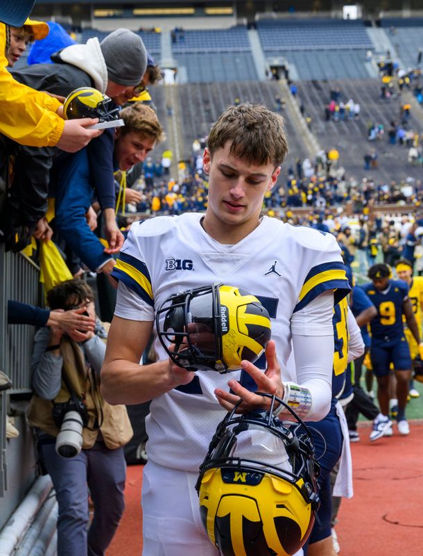 Michigan freshman QB Tommy Carr autographs items for fans after playing in the Maize vs. Blue Spring Football Game at Michigan Stadium in Ann Arbor on Saturday, April 18, 2026.