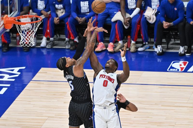 The Pistons' Jalen Duren (0) and the Magic's Paolo Banchero battle for the ball on Sunday at Little Caesars Arena in Detroit.