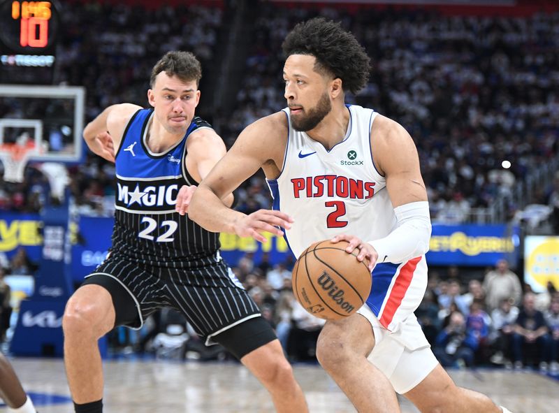 Detroit Pistons guard Cade Cunningham (2) drives past Orlando Magic forward Franz Wagner (22) in the first half at Little Caesars Arena on Sunday, April 19, 2026, in Detroit.