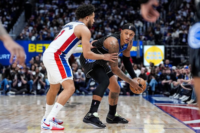 Detroit Pistons guard Cade Cunningham (2) defends Orlando Magic forward Paolo Banchero (5) during the second half of Game 1 of the first round of the NBA playoffs at Little Caesars Arena in Detroit on Sunday, April 19, 2026.