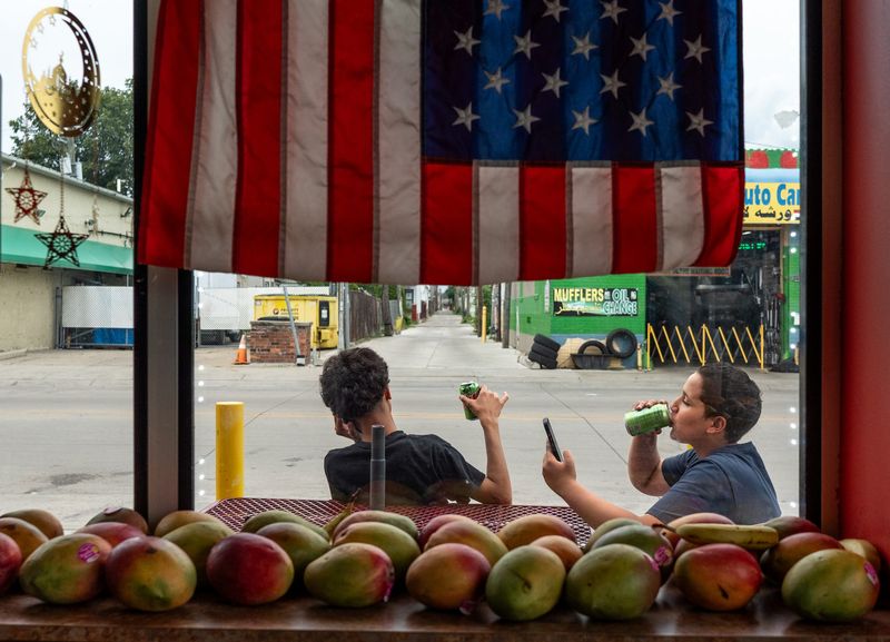 Barry Edmonds Michigan Understanding Award: Teenagers drink cans of pop while sitting outside of Boostan Cafe in Hamtramck on Thursday July 4, 2024.