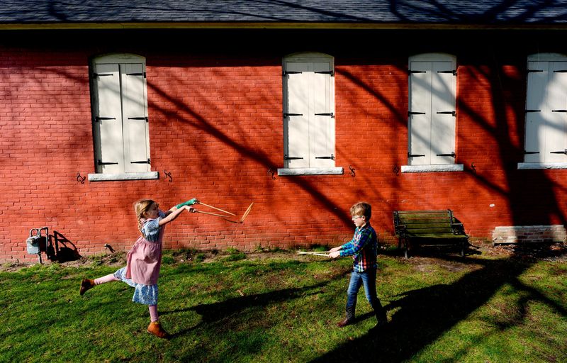 Avery Hester, 8 and Erich Bergmann, 7, play with toys kids would use for recess in the 1800s during a field trip to the Cook Schoolhouse, also known as Fractional District No. 9 School in Grosse Pointe Woods on Friday, April 17, 2026. Several students from Sarah Neely’s class at Lewis Maire Elementary School in Grosse Pointe had a history lesson on how school was for kids their age back in the late 1890s.