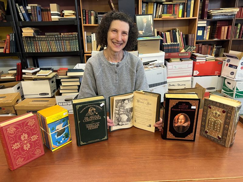Sharon Resnick, facilities liaison for Bookstock, with some of the special selections that will be featured at this year's sale, set for April 26-May 3 at Laurel Park Place in Livonia.