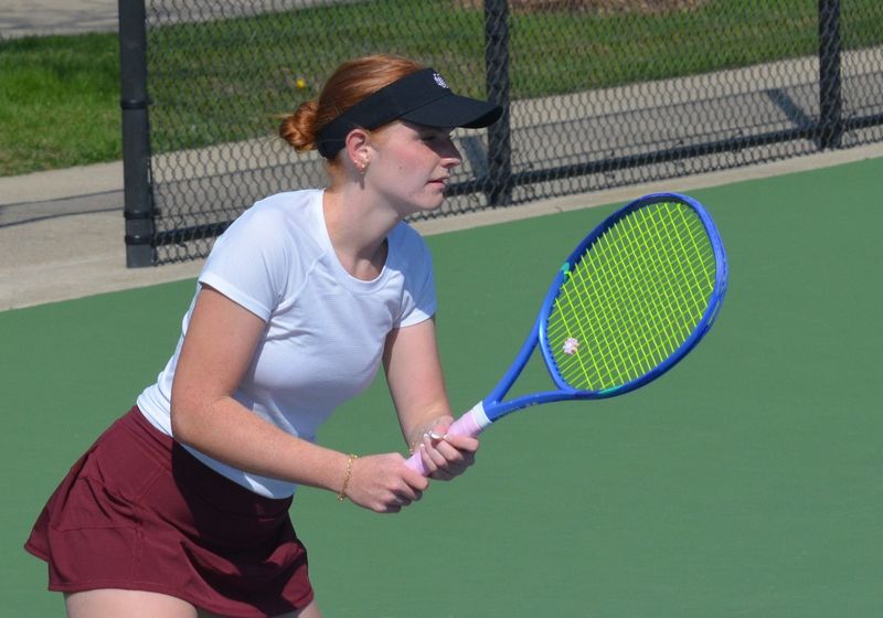 Holland Christian's Camryn Nadig prepares to return a serve against Holland on Wednesday, April 22.