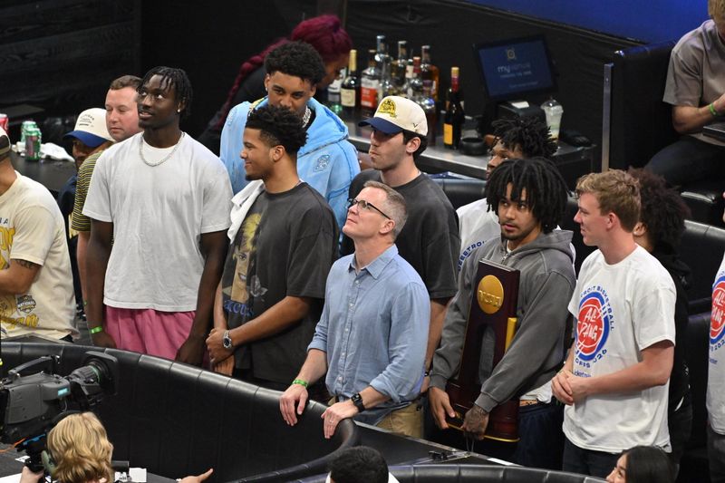 Members of the Michigan men's basketball team, including head coach Dusty May, attend the Pistons playoff game Wednesday, April 22, 2026, at Little Caesars Arena in Detroit.