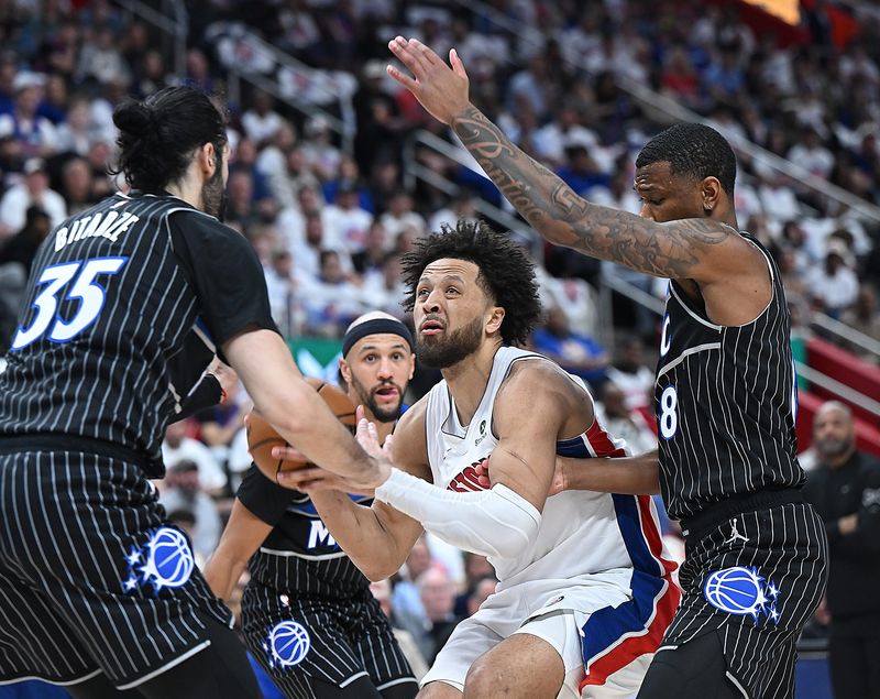 Detroit Pistons guard Cade Cunningham (2) looks for room around Orlando Magic center/forward Goga Bitadze (35) aand Orlando Magic forward Jamal Cain (8) in the first half. Detroit Pistons vs Orlando Magic, Round 1/Game 2 at Little Caesars Arena on Wednesday, April 22, 2026, in Detroit, Mich