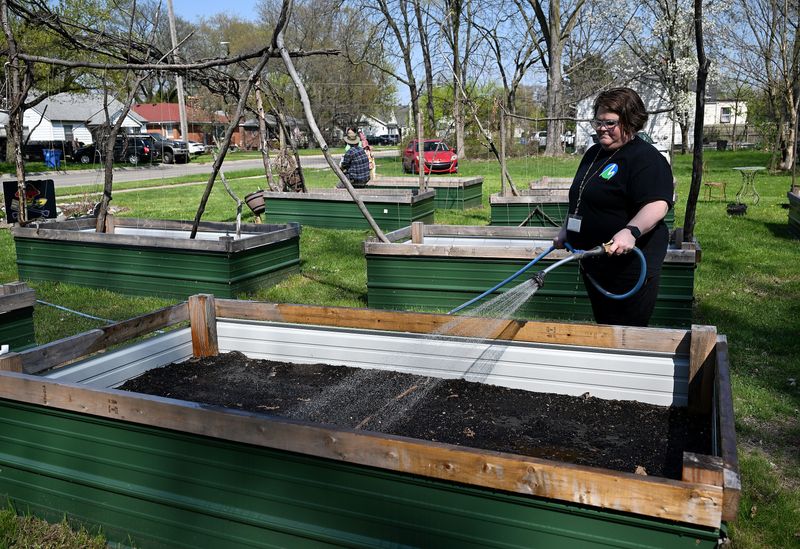 Garden volunteer Kat Strong of Eastpointe waters the raised garden beds on April 22, 2026 at the South Warren Community Garden in Warren, Mich.