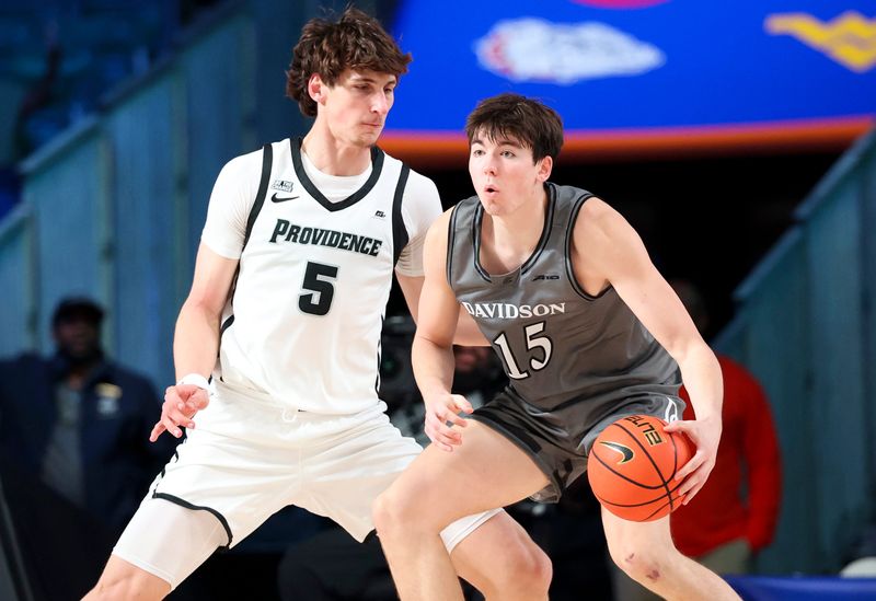 Nov 28, 2024; Paradise Island, Bahamas, BHS; Davidson Wildcats forward Sean Logan (15) dribbles as Providence Friars center Anton Bonke (5) defends during the first half at the Imperial Arena at the Atlantis Resort. Mandatory Credit: Kevin Jairaj-Imagn Images
