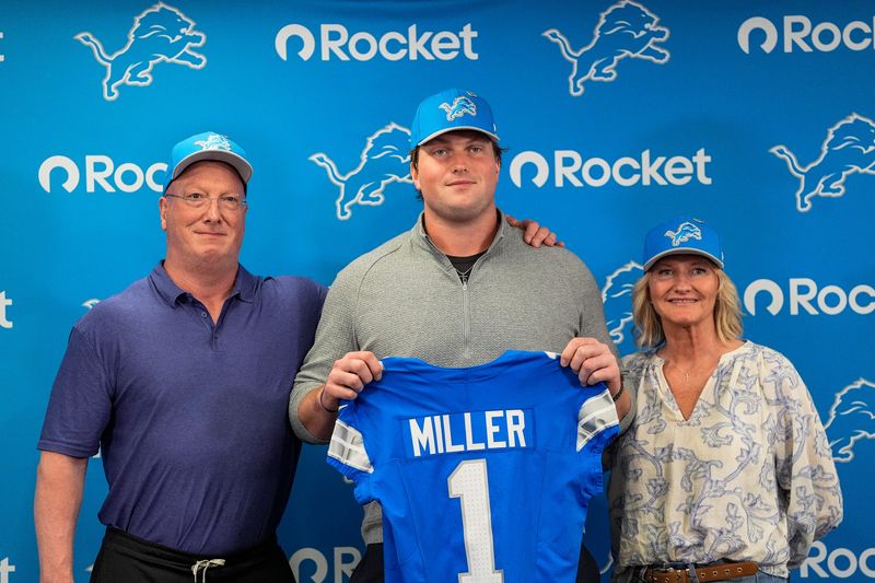 Detroit Lions first round draft Blake Miller, center, poses for a photo with his father Chris Miller, left, and mother Karen Miller at his introductory press conference at Meijer Performance Center in Allen Park on Friday, April 24, 2026.