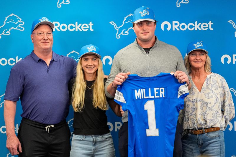 Detroit Lions first round draft Blake Miller, center, poses for a photo with his father Chris Miller, left, girlfriend Kylie Jicha, center left, and mother Karen Miller at his introductory press conference at Meijer Performance Center in Allen Park on Friday, April 24, 2026.