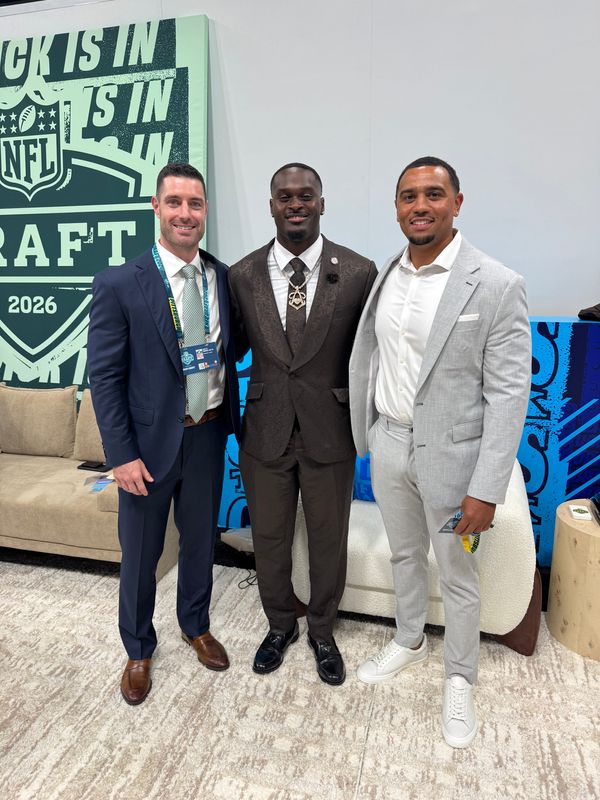 Lansing Eastern graduate and Athletes First agent Travis Allen, far right, is pictured with Notre Dame running back Jeremiyah Love, middle, on Thursday, April 23, 2026, during the NFL draft in Pittsburgh. Allen is an agent for Love, who was selected with the No. 3 pick by the Arizona Cardinals.
