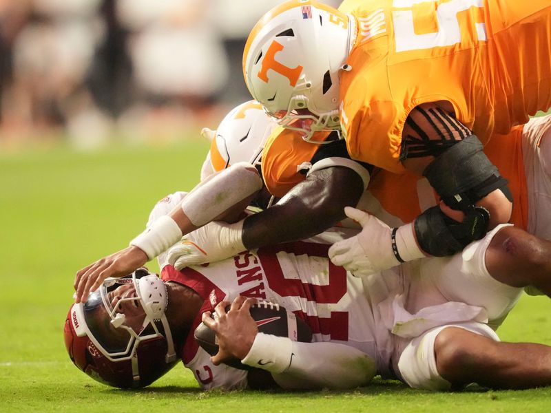 Arkansas quarterback Taylen Green (10) is sacked by Tennessee defensive linemen Jaxson Moi (51) and Tyre West (42) in an NCAA college football game on Oct. 11, 2025, in Knoxville, Tennessee.