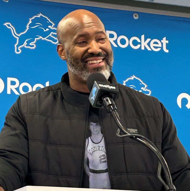 Detroit Lions general manager Brad Holmes wears a T-shirt paying tribute to retiring team president Rod Wood and his time playing basketball for Goodrich, Saturday, April 25, 2026, in Allen Park on Day 3 of the NFL draft.