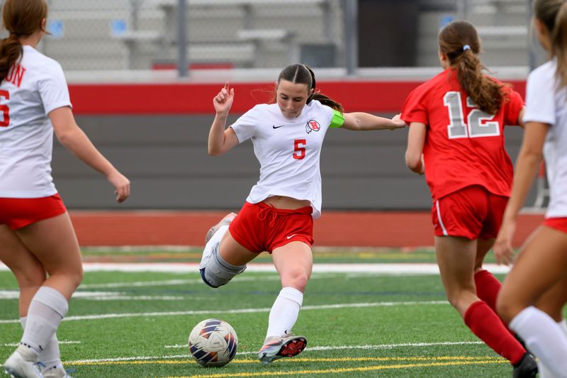 Huron’s Maggie Mentzer passes the ball during a soccer game between New Boston Huron and Grosse Ile, at Grosse Ile High School, April 27, 2026.
