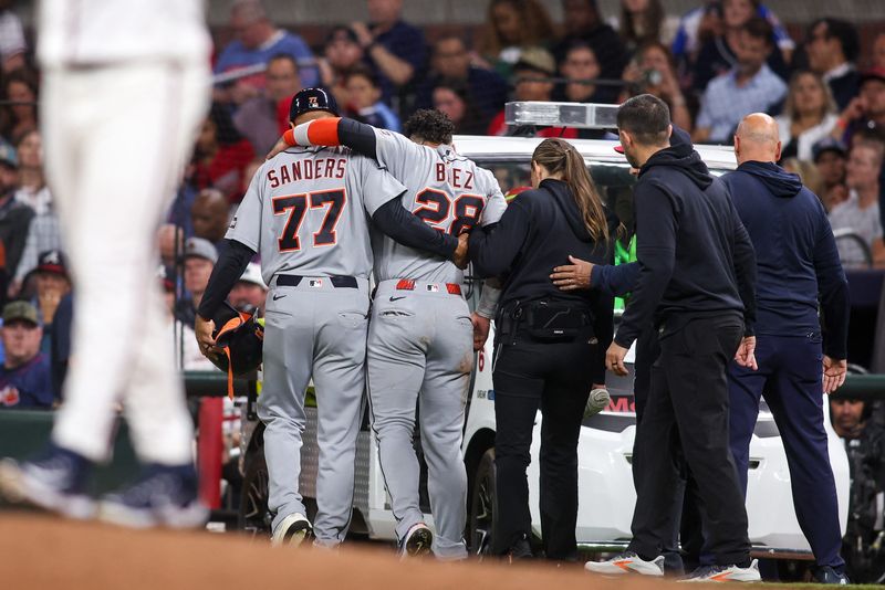 Apr 28, 2026; Atlanta, Georgia, USA; Detroit Tigers center fielder Javier Baez (28) is assisted by first base coach Anthony Sanders (77) after an injury against the Atlanta Braves in the fifth inning at Truist Park. Mandatory Credit: Brett Davis-Imagn Images