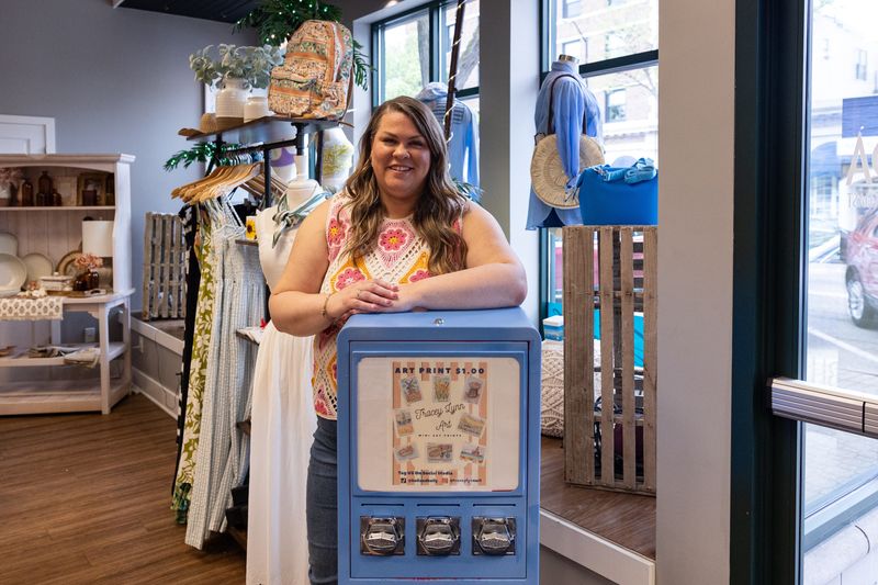 Tracey Venema poses behind her art print vending machine in downtown Holland on April 28.