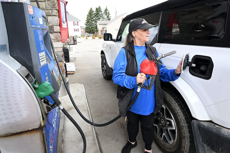 Lorraine Morical, 72, of Oakland Township, finishes filling the tank on April 30, 2026 at the Mobil gas station in Lake Orion. Morical said the price of gas has skyrocketed from $3.99 a gallon to $4.89 in less than a week.