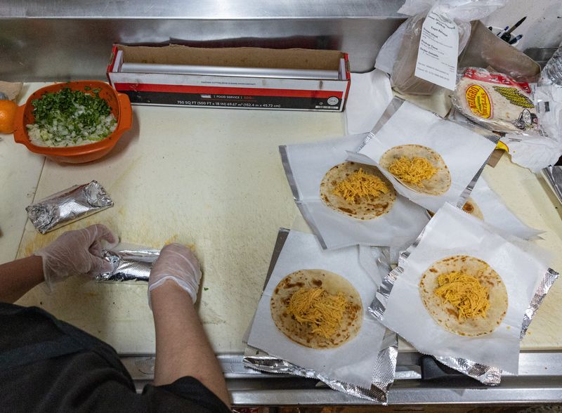 Employees prepare to-go taco orders before the lunch rush at Mi Favorita Grocery on Thursday, April 30.