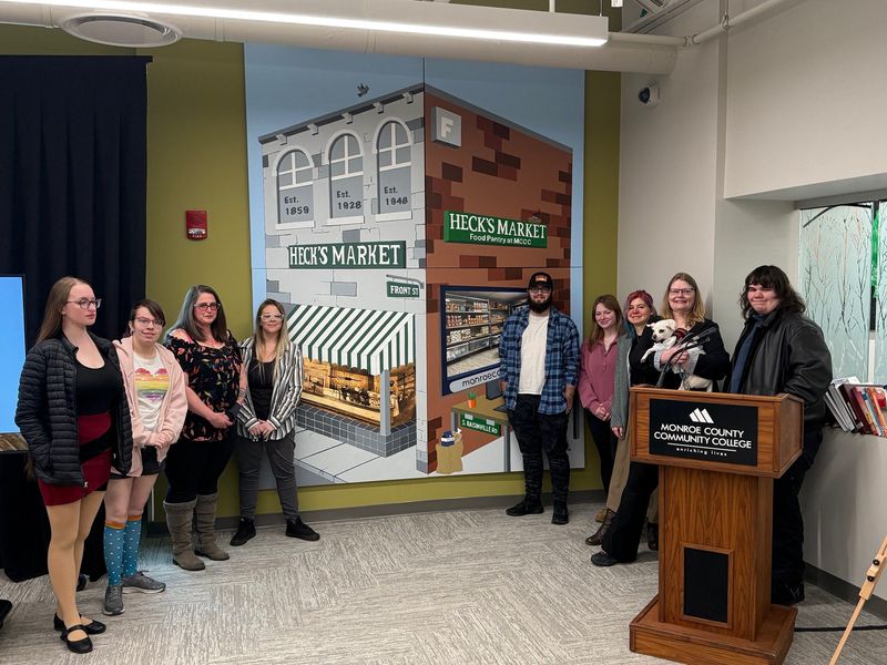Members of the Monroe County Community College Art club pose with the Heck's Market mural.