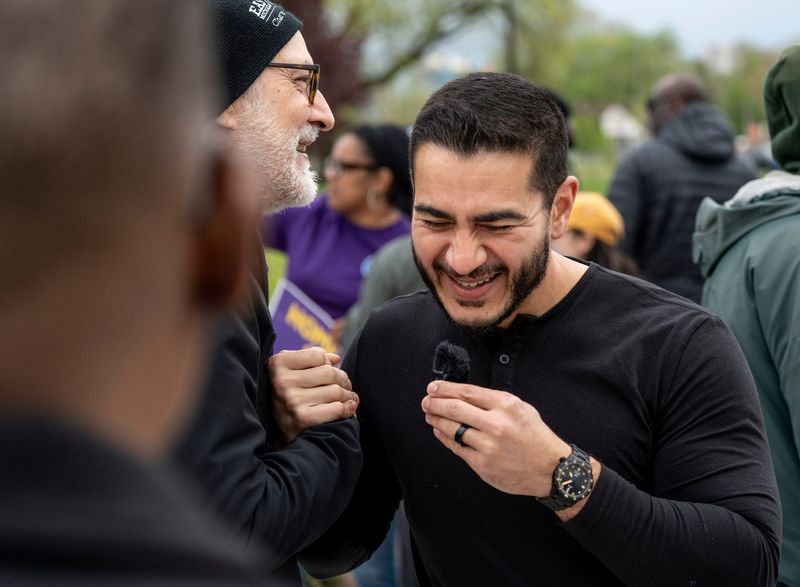 Former Wayne County and Detroit health director Abdul El Sayed, right, interviews Peter Putnam, of Detroit, as union workers and protesters rally to mark May Day, also known as International Worker’s Day, at Roosevelt Park in Detroit on Friday, May 1, 2026, to push back against President Trump.