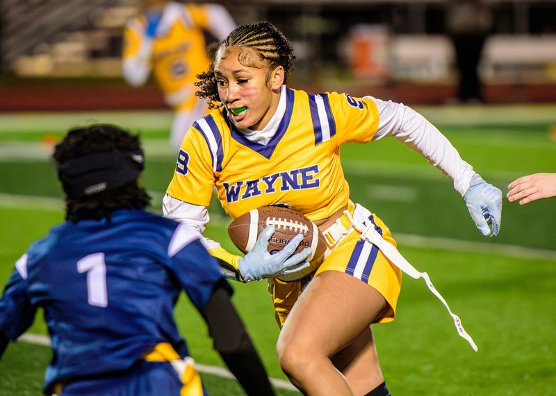 Wayne Memorial's Skyann Penn returns an interception for a TD during a Michigan Girls High School Flag Football League game on Friday, May 1, 2026.