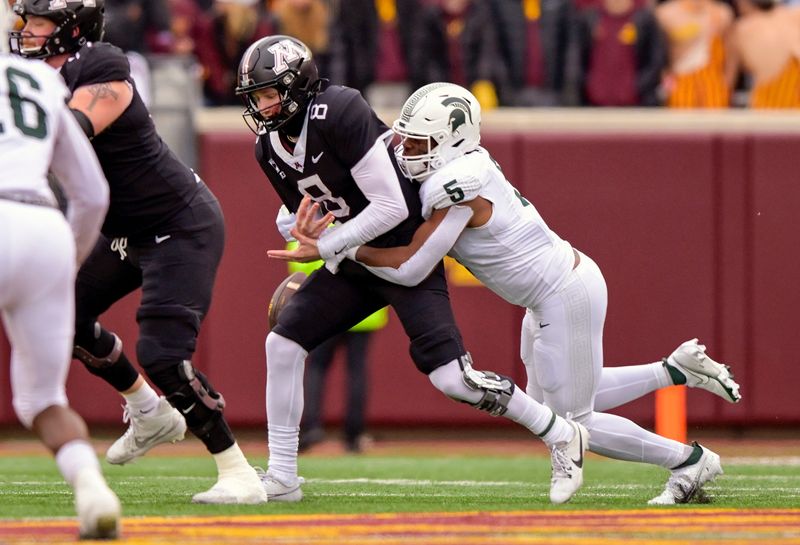 Oct 28, 2023; Minneapolis, Minnesota, USA; Minnesota Golden Gophers quarterback Athan Kaliakmanis (8) is sacked by Michigan State Spartans linebacker Jordan Hall (5) during the first quarter at Huntington Bank Stadium. Mandatory Credit: Nick Wosika-USA TODAY Sports