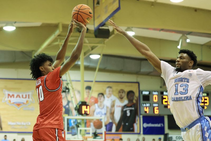 Nov 25, 2024; Lahaina, Hawaii, USA; Dayton Flyers guard Hamad Mousa (10) attempts a three pointer over North Carolina Tar Heels forward Jalen Washington (13) during the first half of an NCAA college basketball game at Lahaina Civic Center. Mandatory Credit: Marco Garcia-Imagn Images