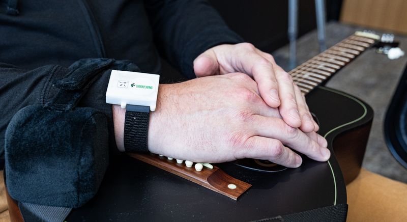 James Lenger, founder of Sharp and Flat, rests his hands on his guitar May 5 in Holland.