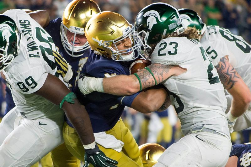 Sep 17, 2016; South Bend, IN, USA; Notre Dame Fighting Irish quarterback DeShone Kizer (14) fights his way into the end zone as Michigan State Spartans linebacker Chris Frey (23) defends in the fourth quarter at Notre Dame Stadium. MSU won 36-28. Mandatory Credit: Matt Cashore-USA TODAY Sports