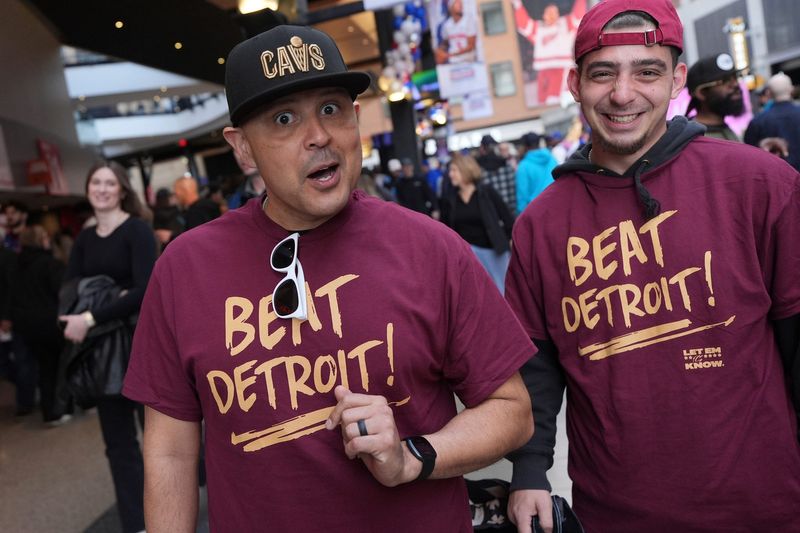 Rick Amador, 46, of Lorain, Ohio, and his coworker Eric Karr, 24, of Strongsville, Ohio, attend Game 2 of the NBA playoffs between the Detroit Pistons and the Cleveland Cavaliers at Little Caesars Arena in Detroit, Thursday, May 7, 2026. Amador, a season ticket holder, and Karr said Dan Gilbert, Cavs owner, paid for 7 bus loads of fans to come to Detroit for the game and treated them to dinner at the Beacon Room before the game.
