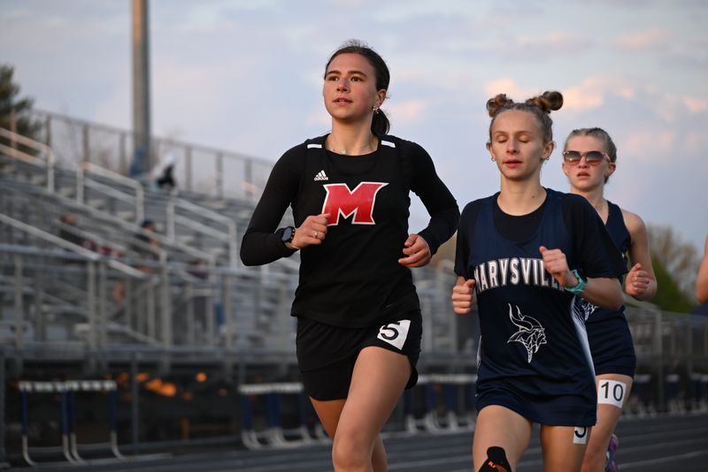 Cardinal Mooney's Stella Behnan (left) runs during the Marysville Invitational earlier this month.