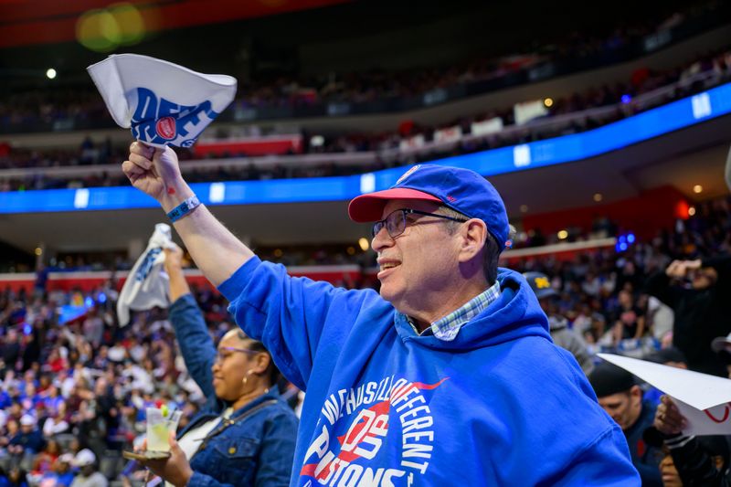 Dan Bellmore of East Lansing, center, watches Game 2 of the NBA semifinals between the Detroit Pistons and the Cleveland Cavaliers at Little Caesars Arena in Detroit, May 7, 2026. Despite fighting a rare brain disease, "my enthusiasm for the game and the team will never end," Bellmore said.
