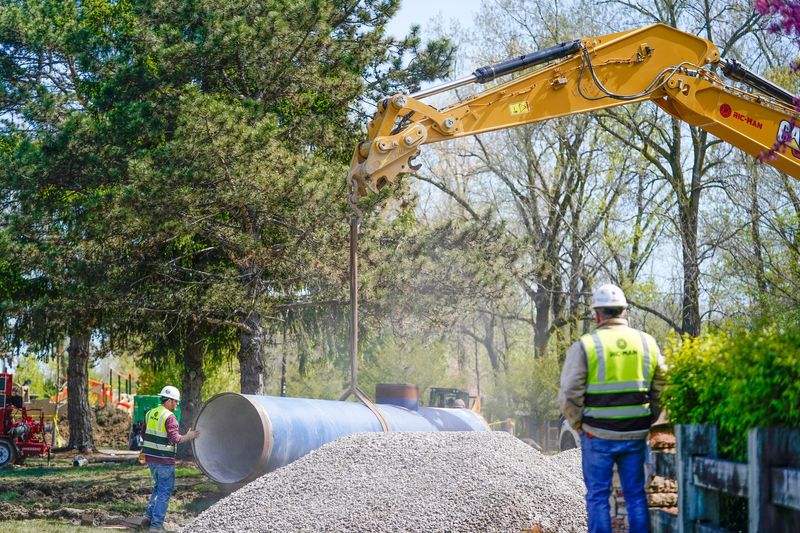 Workers install a large pipe at the site of a water main break in Auburn Hills on Monday, May 11, 2026.