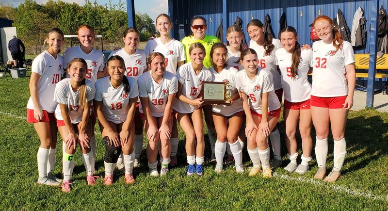 New Boston Huron's girls soccer team poses with the trophy after beating Airport 7-4 to wrap up its third consecutive Huron League championship on Monday, May 11, 2026.