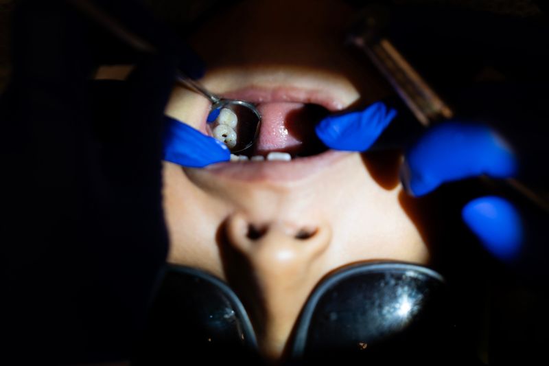 Dentist Francesca Malensek and assistant Vanessa Zuniga spot a cavity in Ricardo’s mouth during a mobile dental clinic visit at St. Adalbert School on the morning of May 13, 2026 Milwaukee, Wisconsin.