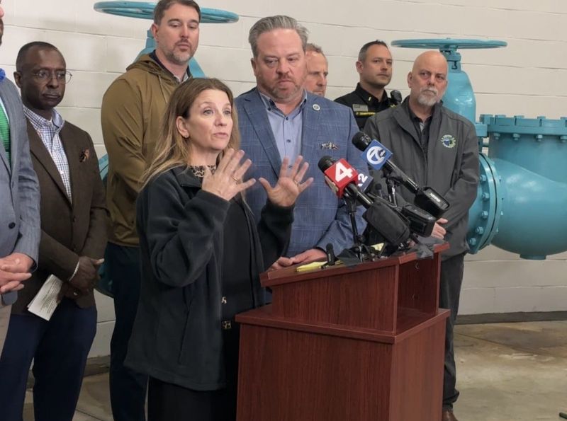 Great Lakes Water Authority CEO Suzanne Coffey speaks to reporters alongside Orion Township Supervisor Chris Barnett, center, on Wednesday, May 13, 2026, at the township water tower.